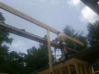 Carpenter setting a ridge beam over a new addition frame — Ice Dam Removal by Roofing Brothers in Seabrook
